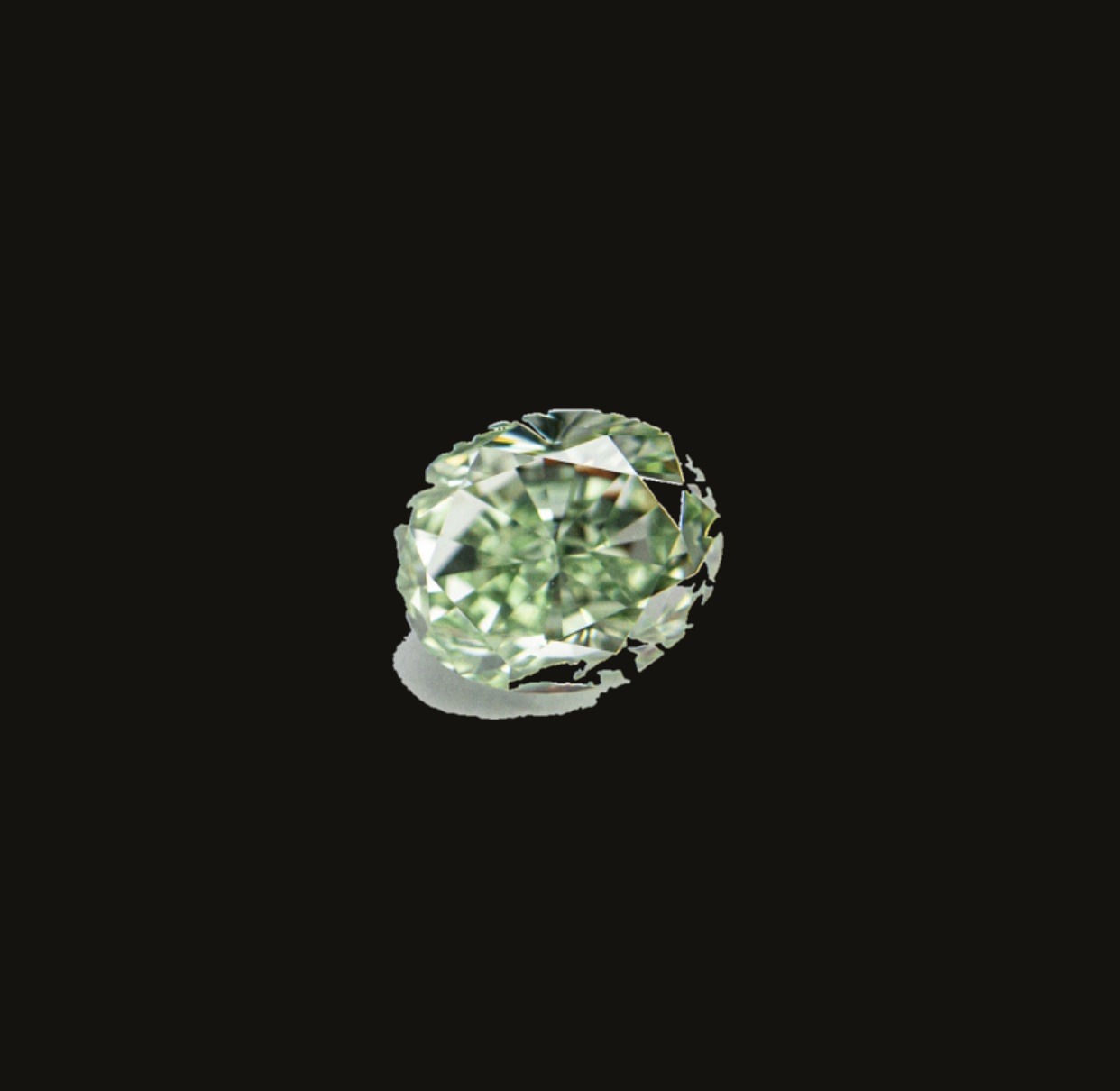 A loose fancy green diamond, oval cut, on a dark background